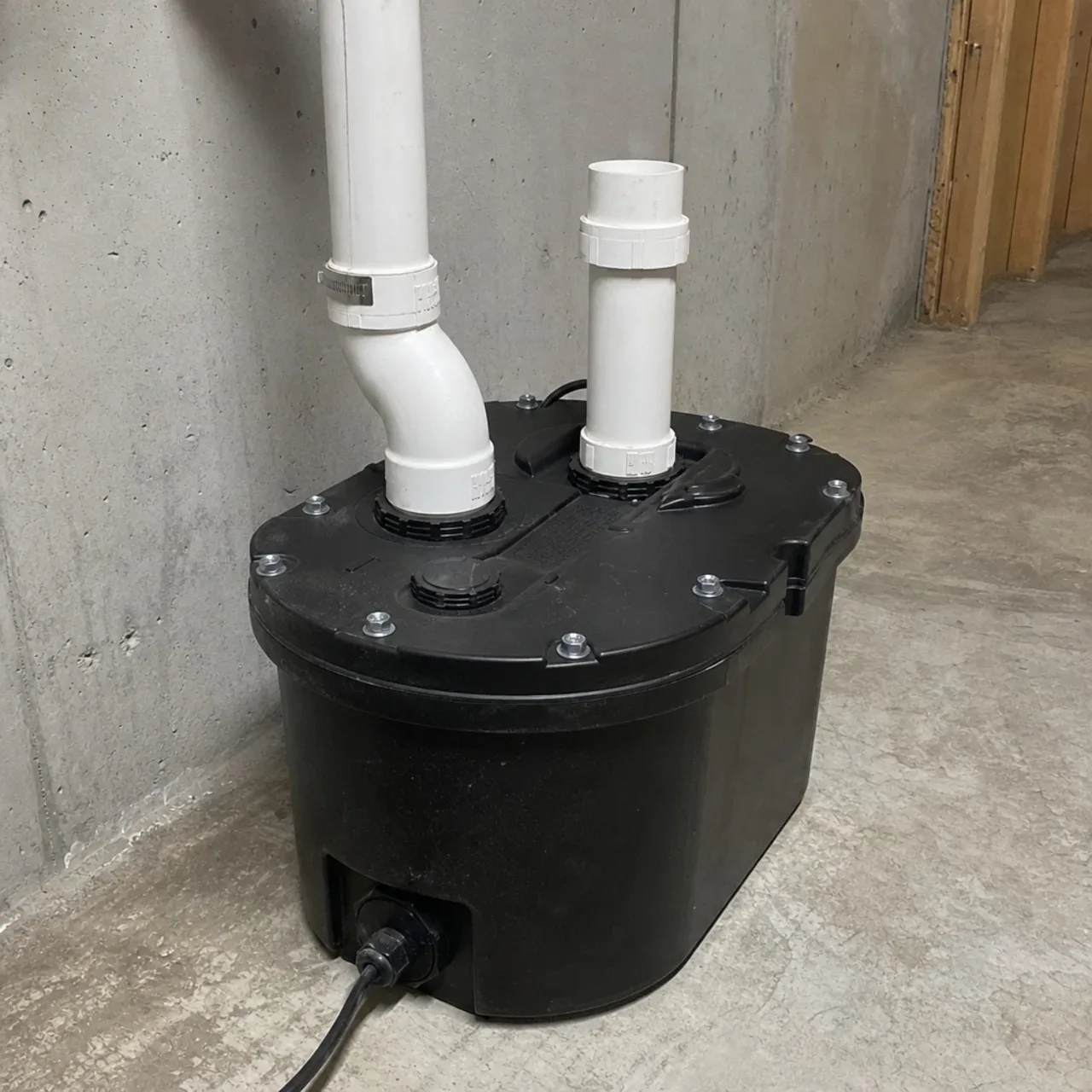 Sealed sewage ejector basin and pipe connections